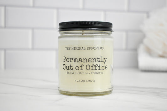 Candle with 'The Minimal Effort Co.' label on a white surface