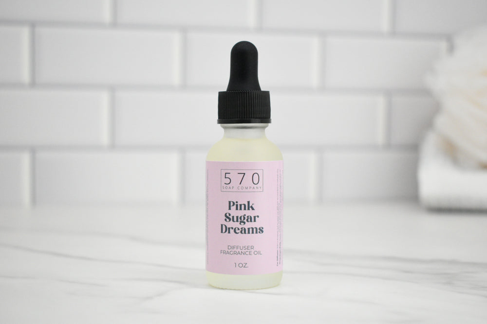 Bottle of 'Pink Sugar Dreams' diffuser oil with dropper on a white tiled background