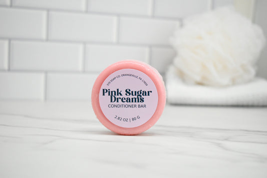 Pink Sugar Dreams conditioner bar on a white tiled background