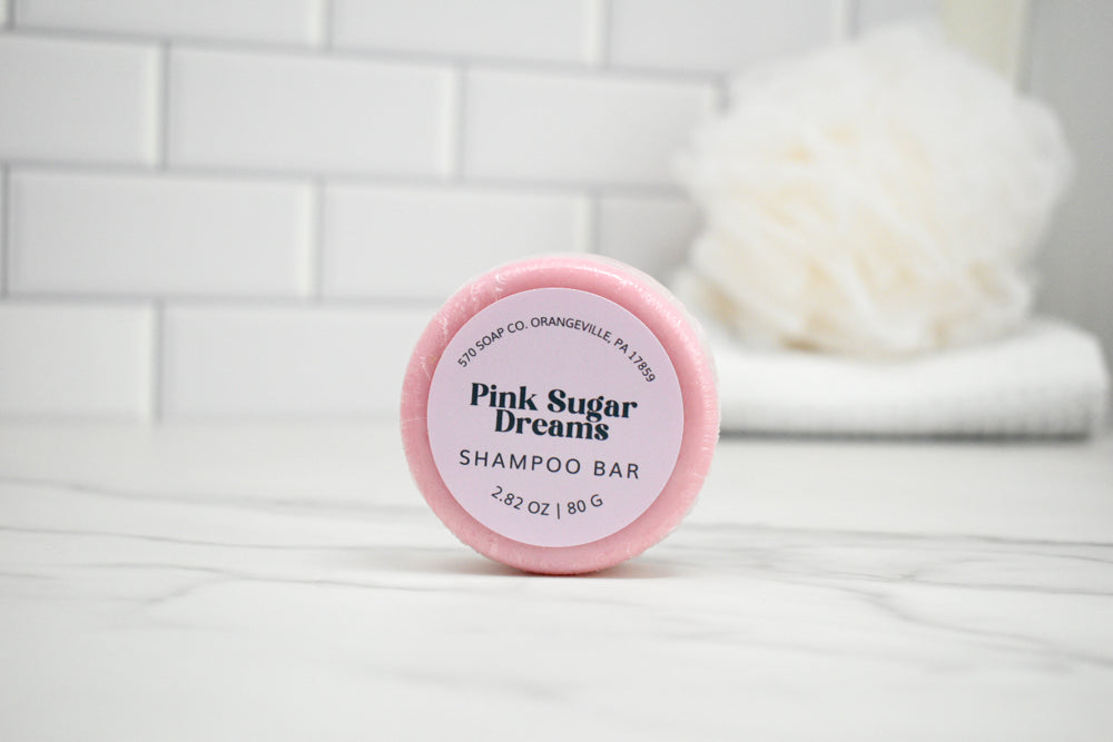 Pink Sugar Dreams shampoo bar on a white surface with a tiled wall background