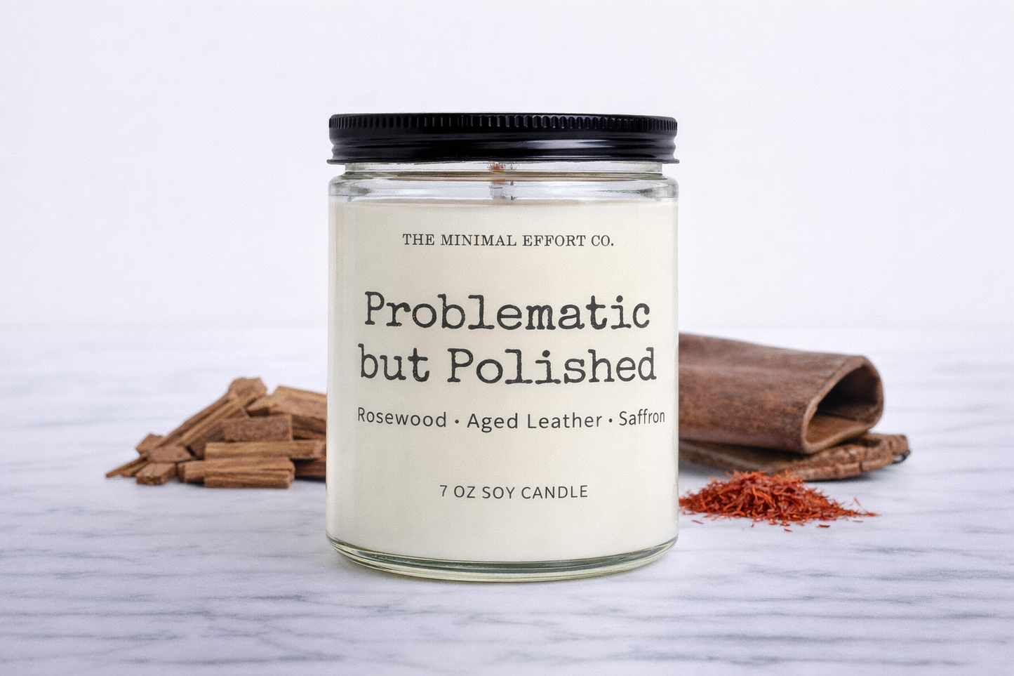 Candle with a label on a white surface with cinnamon sticks and saffron.