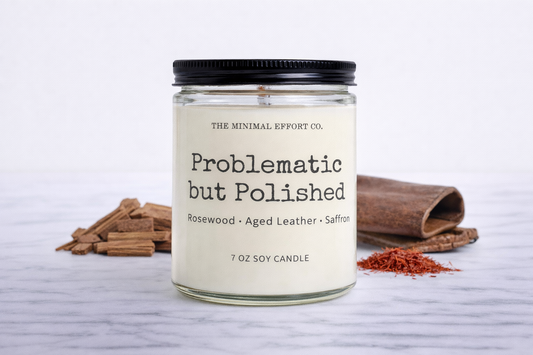 Candle with a label on a white surface with cinnamon sticks and saffron.