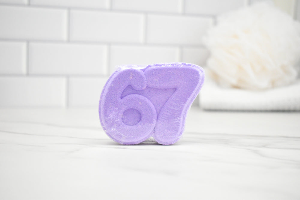 Purple bath bomb with the number 67 on a white surface
