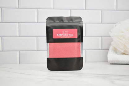 Pink powder in a black packaging bag with a pink label on a white tiled background