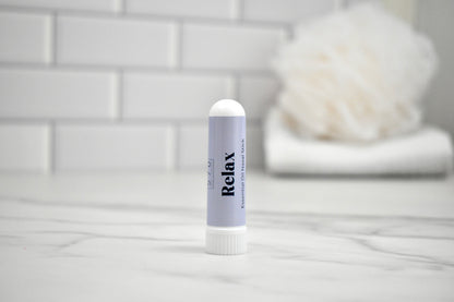 Nasal Stick labeled 'Relax' on a bathroom counter with a blurred background