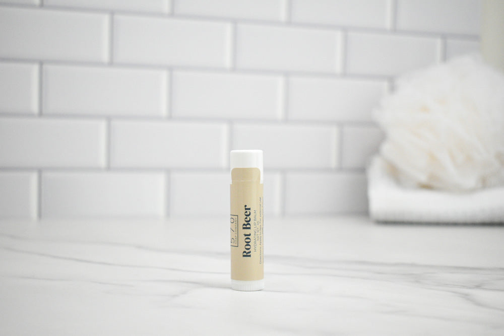 Bottle of Red Beer lip balm on a white surface with a tiled wall background