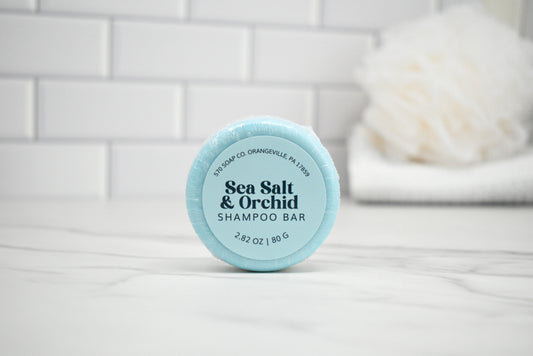 Shampoo bar with 'Sea Salt & Orchid' label on a white surface with a tiled wall background