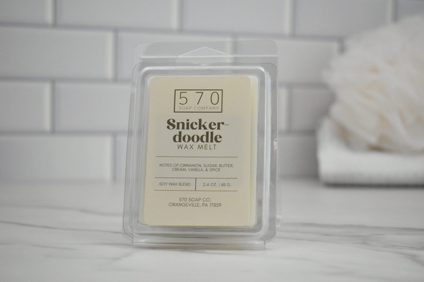 Snickerdoodle wax melt packaging on a tiled bathroom counter