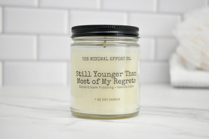 Candle in a glass jar with a black lid on a white surface