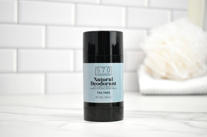 570 Natural Deodorant stick on a white surface with a tiled wall background