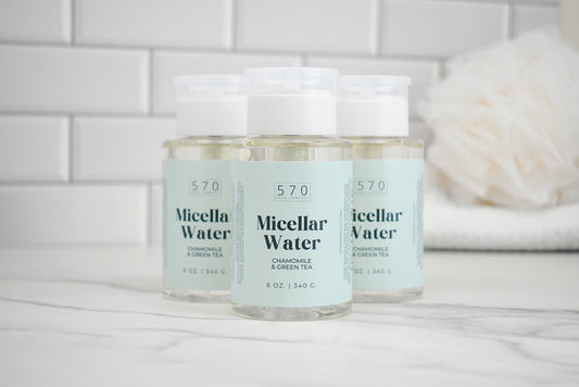 Three bottles of 570 Micellar Water on a white surface with a tiled wall background.
