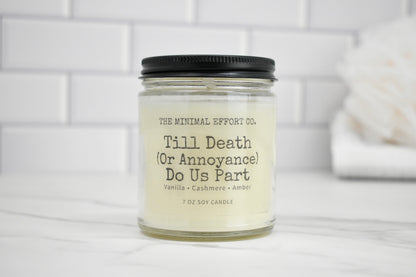 Candle jar labeled 'Till Death (Or Annoyance) Do Us Part' on a white surface with a tiled wall background.