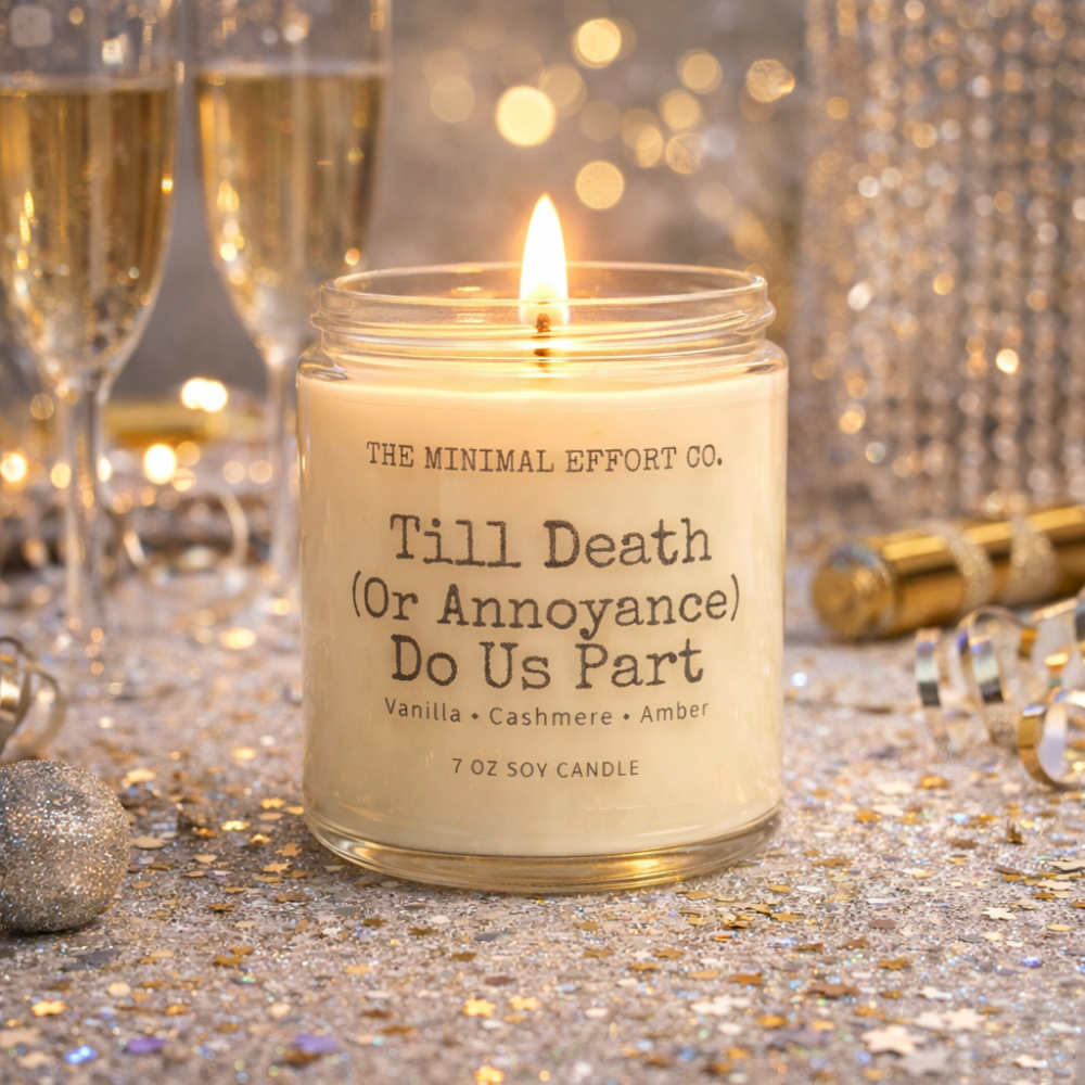 Candle with a humorous label in a festive setting with champagne glasses and confetti.