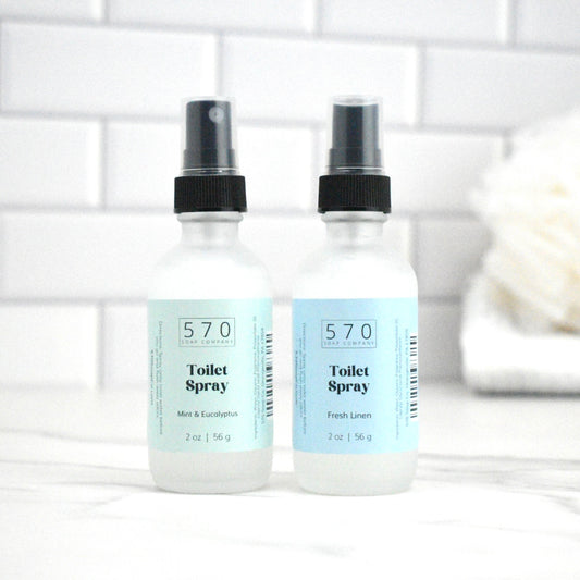 Two bottles of 570 Toilet Spray on a white surface with a blurred background