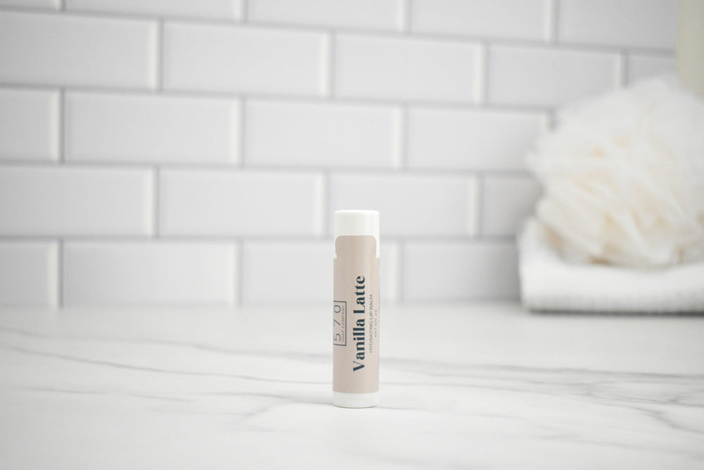 Tube of vanilla latte on a white surface with a tiled wall background