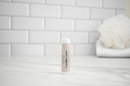 Tube of vanilla latte on a white surface with a tiled wall background