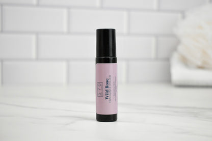 Roll-on bottle with pink label on a white surface with a tiled wall background
