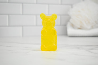 Yellow bear-shaped soap on a white surface with a tiled wall background