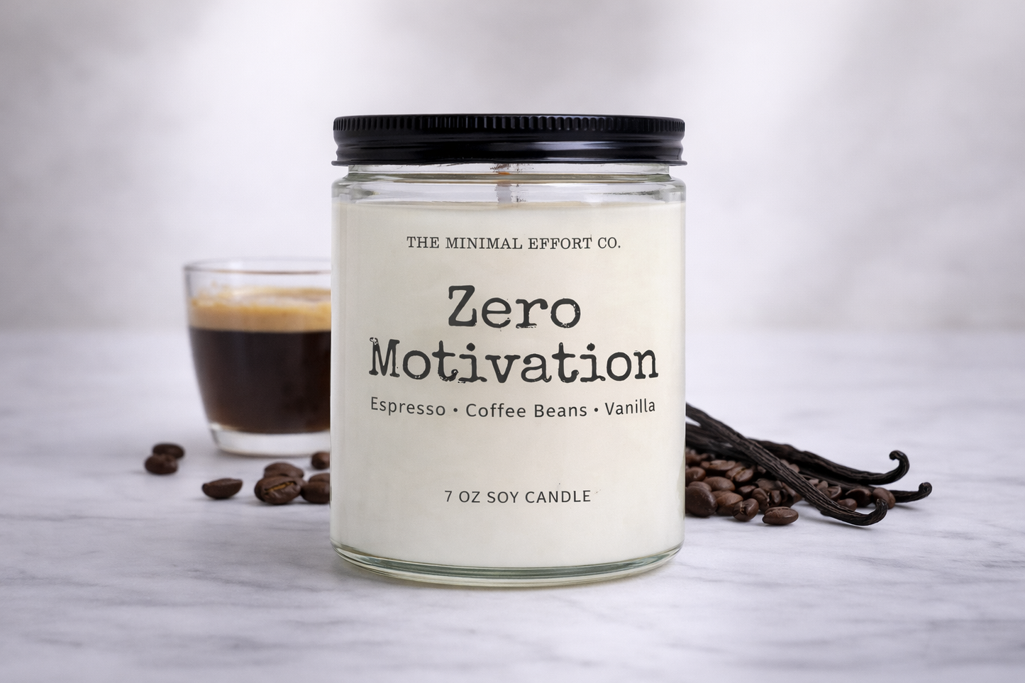 Candle labeled 'Zero Motivation' with coffee beans and a glass of coffee on a light background