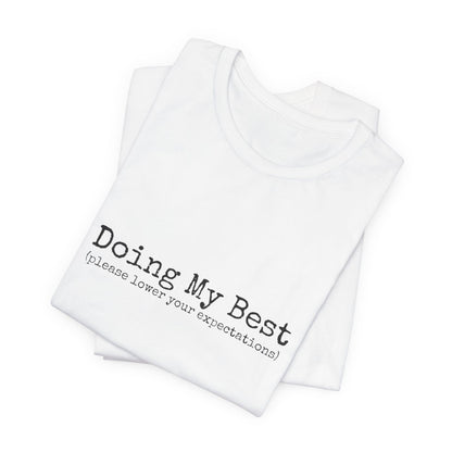 White tank top with text 'Doing My Best (please lower your expectations)' on a white background